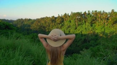 Campuhan sırt yürüyüş veya Ressamlar Ubud yürüyüş gün batımı sırasında yürüyen sarı elbiseli genç bir kadının Süper slowmotion çekim. Bali'deki seyahat noktaları. Travell bali kavramı.