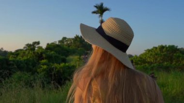 Campuhan sırt yürüyüş veya Ressamlar Ubud yürüyüş gün batımı sırasında yürüyen sarı elbiseli genç bir kadının Süper slowmotion çekim. Bali'deki seyahat noktaları. Travell bali kavramı.