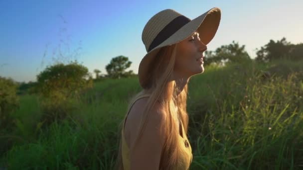 Super slowmotion skott av en ung kvinna i en gul klänning promenader under solnedgången på Campuhan Ridge Walk eller målare gångväg i Ubud. Travell destinationer på Bali. Travell till Bali Concept. — Stockvideo