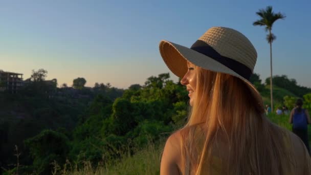 Super slowmotion strzał młodej kobiety w żółtej sukni spaceru podczas zachodu słońca w Campuhan Ridge walk lub malarzy chodnik w Ubud. Travell miejsc na Bali. Koncepcja Travell do Bali. — Wideo stockowe