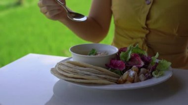 genç bir kadın bir arka planda bir pirinç tarlası ile bir kafede onun küçük oğulları elleri bir sıvı el dezenfektan döken. El dezenfeksiyonu konsepti.