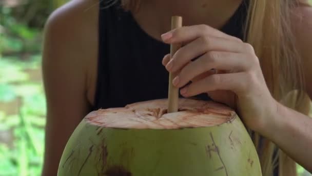 Primer plano de una joven bebiendo cocnut joven en un café de la calle con un campo de arroz en un fondo — Vídeos de Stock