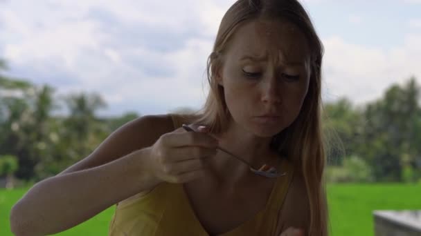 Nahaufnahme einer jungen Frau und ihres kleinen Sohnes, die in einem Café mit einem Reisfeld im Hintergrund traditionelle ostasiatische Mahlzeiten genießen. Anreise zum bali concept. — Stockvideo