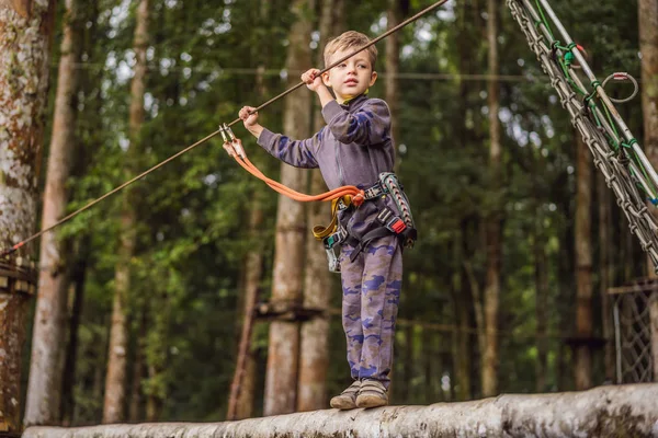 Kleine jongen in een touwenpark. Actieve fysieke recreatie van het kind in de frisse lucht in het park. Opleiding voor kinderen — Stockfoto