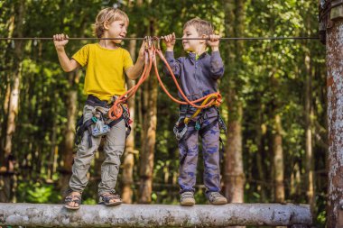 İp parkında iki küçük çocuk. Parkta temiz havada çocuğun aktif fiziksel rekreasyon. Çocuklar için eğitim