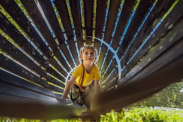 Little boy in a rope park. Active physical recreation of the child in the fresh air in the park. Training for children — Stock Photo, Image