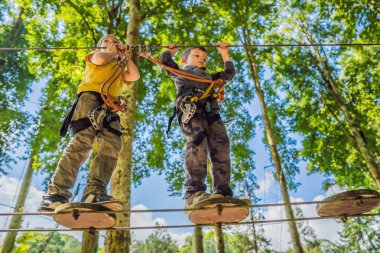 İp parkında iki küçük çocuk. Parkta temiz havada çocuğun aktif fiziksel rekreasyon. Çocuklar için eğitim
