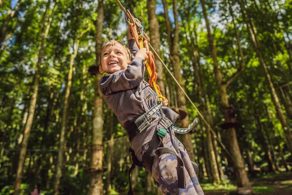 Petit garçon dans un parc à cordes. Loisirs physiques actifs de l'enfant dans l'air frais dans le parc. Formation pour les enfants — Photo