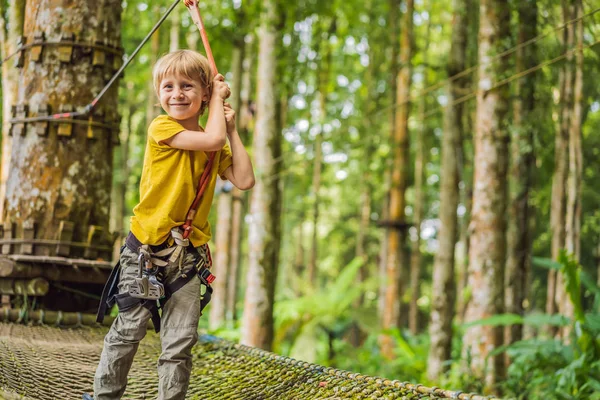 Un ragazzino in un parco di corde. Ricreazione fisica attiva del bambino all'aria aperta nel parco. Formazione per bambini — Foto Stock