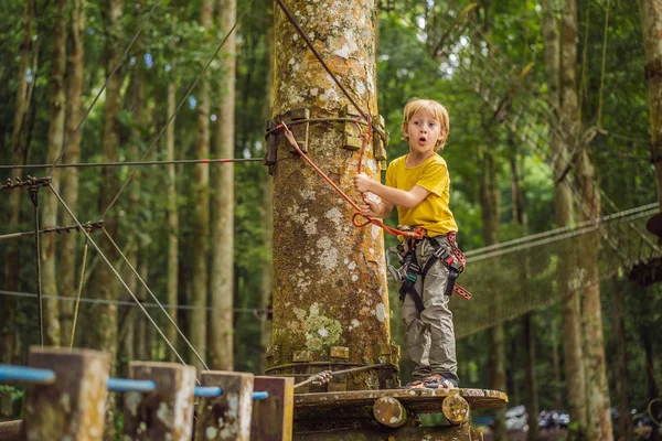 Petit garçon dans un parc à cordes. Loisirs physiques actifs de l'enfant dans l'air frais dans le parc. Formation pour les enfants — Photo