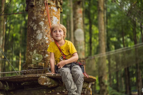 Kleine jongen in een touwenpark. Actieve fysieke recreatie van het kind in de frisse lucht in het park. Opleiding voor kinderen — Stockfoto