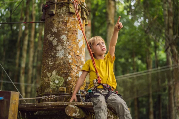 Kleine jongen in een touwenpark. Actieve fysieke recreatie van het kind in de frisse lucht in het park. Opleiding voor kinderen — Stockfoto