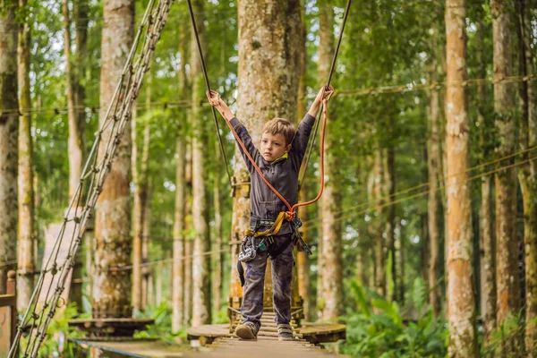 Un ragazzino in un parco di corde. Ricreazione fisica attiva del bambino all'aria aperta nel parco. Formazione per bambini — Foto Stock