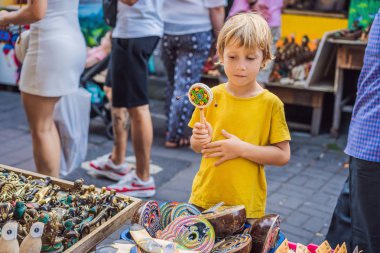 Ubud, Bali'de bir markette çocuk. Ünlü Ubud Market, Endonezya'da Hediyelik eşya ve Bali el sanatları satan tipik hediyelik eşya dükkanı. Bali pazarı. Yerel sakinlerinin ahşap ve el sanatları Hediyelik eşya