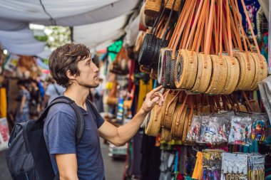 Ubud, Bali'de bir markette adam. Ünlü Ubud Market, Endonezya'da Hediyelik eşya ve Bali el sanatları satan tipik hediyelik eşya dükkanı. Bali pazarı. Yerel sakinlerinin ahşap ve el sanatları Hediyelik eşya