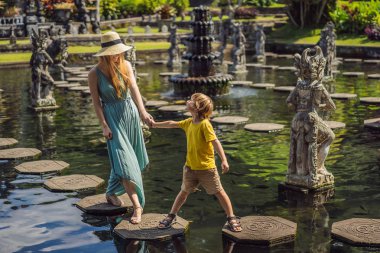 Taman Tirtagangga anne ve oğlu turistler, Su sarayı, Su parkı, Bali Endonezya. Çocuk konsepti ile seyahat. Çocuk dostu bir yer
