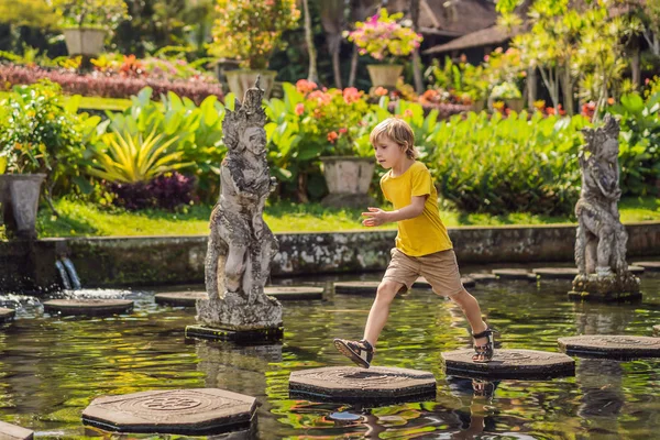 Fiú turista Taman Tirtagangga, víz palota, vízi park, Bali Indonézia. Utazótáska-val gyerekek fogalom. Gyerekbarát hely — Stock Fotó