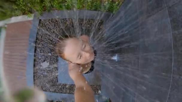 La toma en cámara lenta de una joven toma una ducha en un jardín tropical. Vacaciones en un concepto de resort tropical. Joven vlogger hace un video de sí misma tomando una ducha en un hotel tropical — Vídeo de stock