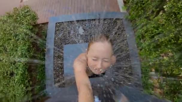 Um tiro em câmera lenta de uma jovem toma banho em um jardim tropical. Férias em um conceito de resort tropical. Mulher jovem vlogger faz um vídeo de si mesma tomando um banho em um hotel tropical — Vídeo de Stock