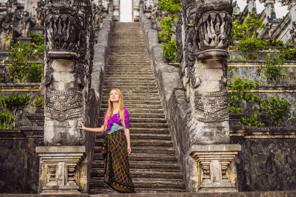 Young woman tourist on background of Three stone ladders in beautiful Pura Lempuyang Luhur temple. Summer landscape with stairs to temple. Paduraksa portals marking entrance to middle sanctum jaba — Stock Photo, Image