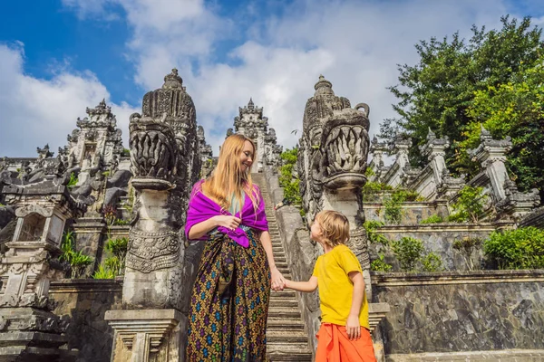 Madre e hijo turistas en el fondo de tres escaleras de piedra en el hermoso templo de Pura Lempuyang Luhur. Paisaje de verano con escaleras al templo. Portales de Paduraksa que marcan la entrada al santuario medio jaba — Foto de Stock