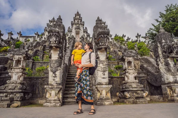 Vader en zoon toeristen op de achtergrond van drie stenen ladders in de prachtige Pura Lempuyang Luhur Tempel. Paduraksa portals markeren ingang naar Midden Sanctum Jaba Tengah van Pura Penataran Agung, Bali — Stockfoto