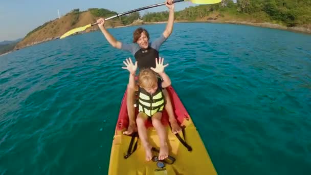 Slowmotion skott av en ung familj kajakpaddling i ett tropiskt hav och ha kul att titta på korallrev och tropiska fiskar under vattnet. Ya Nui Beach på Phuket Island — Stockvideo