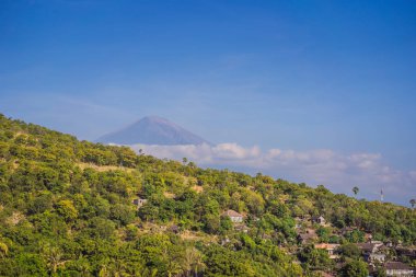 Bali, Endonezya Amed plaj havadan görünümü. Geleneksel balıkçı tekneleri siyah kum plaj ve arka planda Mount Agung yanardağı jukung denilen, kısmen bulutlar ile kaplı