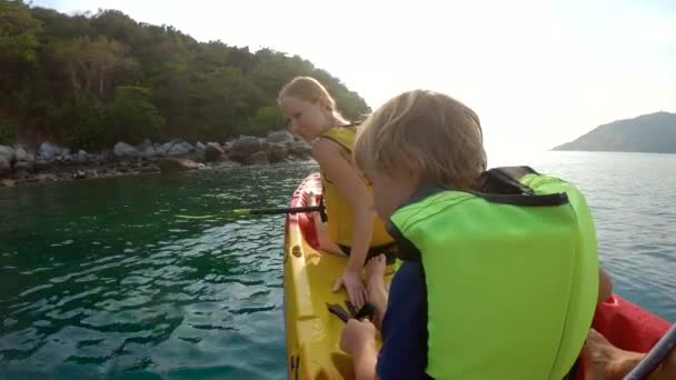 Filmagem em câmera lenta de uma jovem família de caiaque em um mar tropical e se divertindo olhando para recifes de corais e peixes tropicais subaquáticos. Ya Nui Beach na ilha de Phuket — Vídeo de Stock