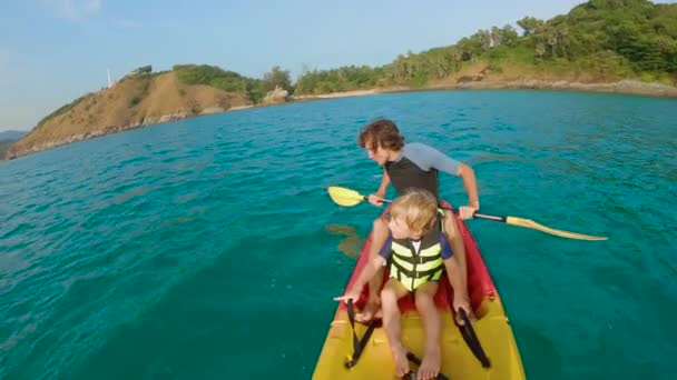 Slowmotion shot egy fiatal családi kajakozás egy trópusi tengerben és szórakozik nézett korallzátonyok és trópusi halak víz alatt. Ya Nui Beach Phuket szigetén — Stock videók