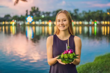 Bir kadın turist Elinde Loy Krathong tutar ve suya başlatmak üzeredir. Loy Krathong festivali, İnsanlar Loy kutlamak için ışık ve su üzerinde yüzen çiçek ve mum satın