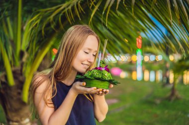 Bir kadın turist Elinde Loy Krathong tutar ve suya başlatmak üzeredir. Loy Krathong festivali, İnsanlar Loy kutlamak için ışık ve su üzerinde yüzen çiçek ve mum satın