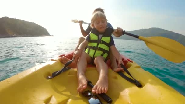 Filmagem em câmera lenta de uma jovem família de caiaque em um mar tropical e se divertindo olhando para recifes de corais e peixes tropicais subaquáticos. Ya Nui Beach na ilha de Phuket — Vídeo de Stock