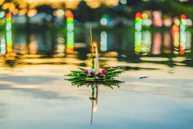 Loy Krathong festivali. İnsanlar Tayland 'daki Loy Krathong festivalini kutlamak için çiçek ve mum alıp suyun üzerinde yüzüyor.
