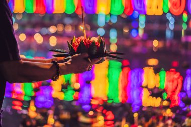 Loy Krathong festivali. İnsanlar Tayland 'daki Loy Krathong festivalini kutlamak için çiçek ve mum alıp suyun üzerinde yüzüyor.