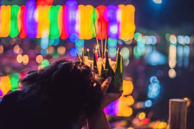 Loy Krathong festivali. İnsanlar Tayland 'daki Loy Krathong festivalini kutlamak için çiçek ve mum alıp suyun üzerinde yüzüyor.