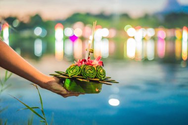 Bir kadın turist Elinde Loy Krathong tutar ve suya başlatmak üzeredir. Loy Krathong festivali, İnsanlar Loy kutlamak için ışık ve su üzerinde yüzen çiçek ve mum satın