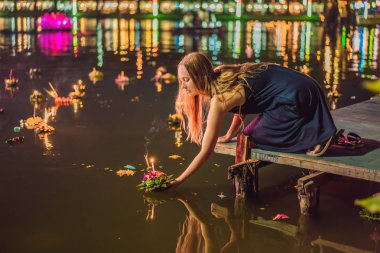 Bir kadın turist Elinde Loy Krathong tutar ve suya başlatmak üzeredir. Loy Krathong festivali, İnsanlar Loy kutlamak için ışık ve su üzerinde yüzen çiçek ve mum satın