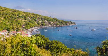 Bali, Endonezya Amed plaj havadan görünümü. Geleneksel balıkçı tekneleri siyah kum plaj ve arka planda Mount Agung yanardağı jukung denilen, kısmen bulutlar ile kaplı