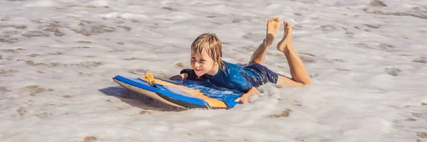 ブギーボードバナー、ロングフォーマットで、休暇中にビーチで楽しんでいる幸せな若い男の子 — ストック写真