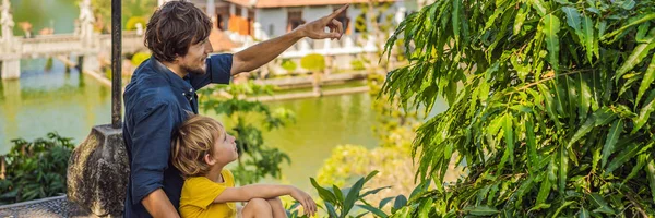 Pai e filho no Palácio da Água Soekasada Taman Ujung Ruínas na Ilha Bali, na Indonésia. Arquitetura antiga incrível. Viagens e feriados fundo. Viajar com conceito de crianças. Crianças Lugares amigáveis BANNER — Fotografia de Stock