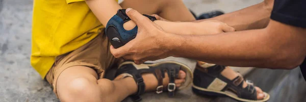 Trainer helps the boy to wear knee pads and armbands before training skate board BANNER, LONG FORMAT — Stock Photo, Image