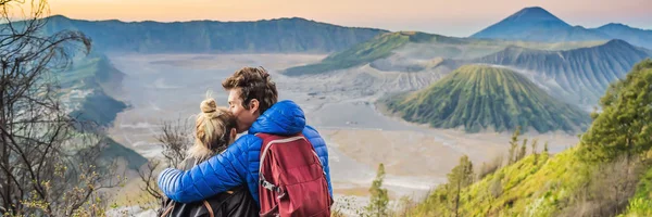 BANNER, FORMATO LARGO Pareja joven hombre y mujer se encuentran con el amanecer en el Parque Nacional Bromo Tengger Semeru en la isla de Java, Indonesia. Disfrutan de magníficas vistas sobre el Bromo o Gunung Bromo en — Foto de Stock