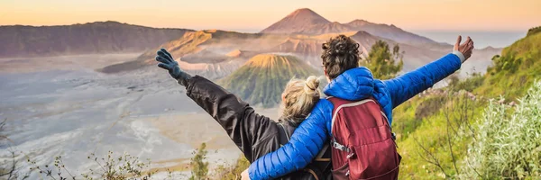 BANNER, LONG FORMAT Young couple and woman meet the sunrise at the Bromo Tengger Semeru National Park on the Java Island, Indonesia. Они наслаждаются великолепным видом на Бромо или Гунунг Бромо на — стоковое фото