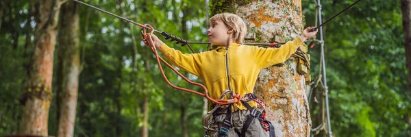 Kleine jongen in een touw park. Actieve fysieke recreatie van het kind in de frisse lucht in het Park. Training voor kinderen banner, lang formaat — Stockfoto