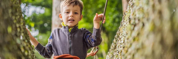 Мальчик в веревочном парке. Активный физический отдых ребенка на свежем воздухе в парке. Обучение для детей BANNER, LONG FORMAT — стоковое фото
