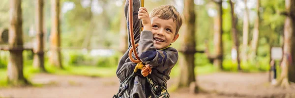 Little boy in a rope park. Active physical recreation of the child in the fresh air in the park. Training for children BANNER, LONG FORMAT — Stock Photo, Image