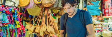 Ubud, Bali'de bir markette adam. Ünlü Ubud Market, Endonezya'da Hediyelik eşya ve Bali el sanatları satan tipik hediyelik eşya dükkanı. Bali pazarı. Yerel sakinlerinin ahşap ve el sanatları Hediyelik eşya