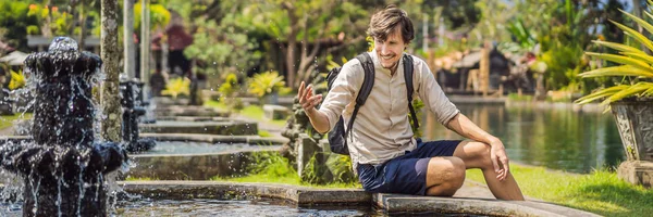 Young man tourist in Taman Tirtagangga, Water palace, Water park, Bali Indonesia BANNER, LONG FORMAT