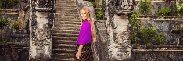 Banner, lang formaat jonge vrouw toerist op de achtergrond van drie stenen ladders in de prachtige Pura Lempuyang Luhur Tempel. Zomer landschap met trappen naar tempel. Paduraksa portals markering toegang tot — Stockfoto